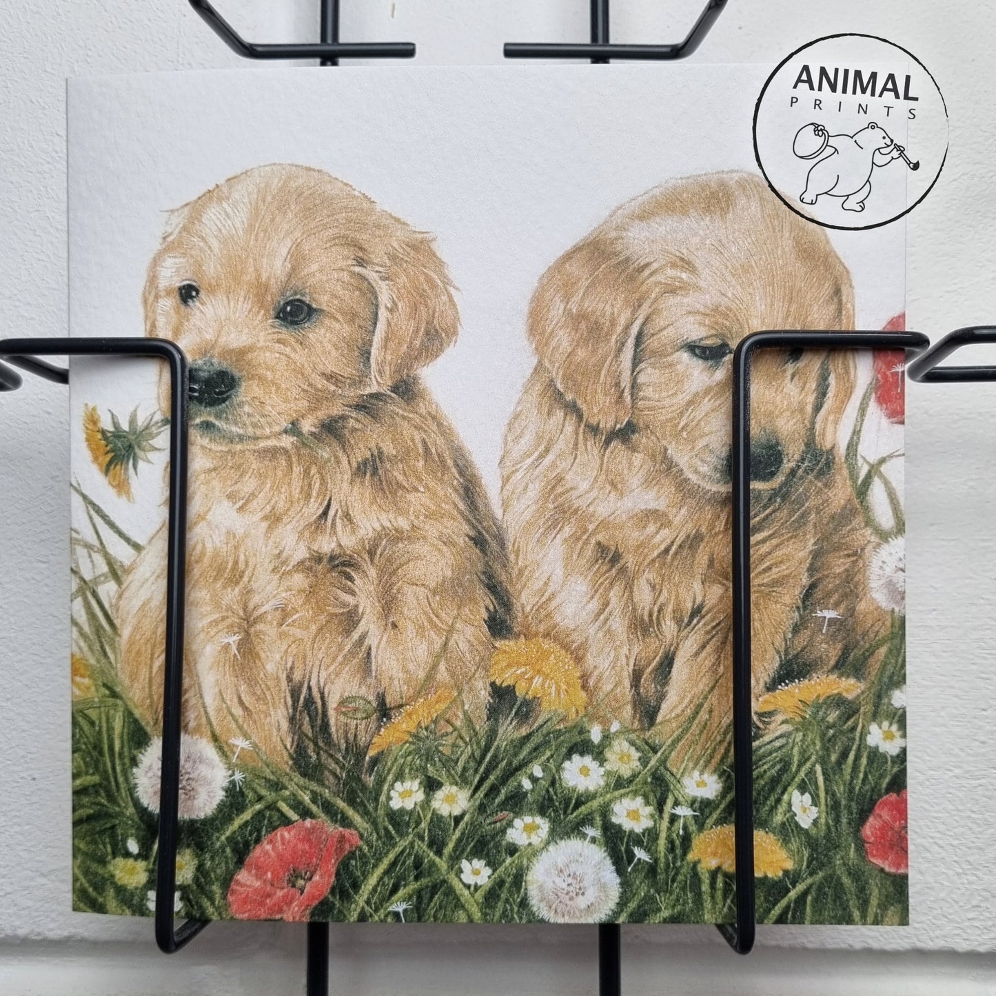 Quadratische Karte - Die Blumen draußen zusammenstellen. Golden Retriever-Welpen im Gras